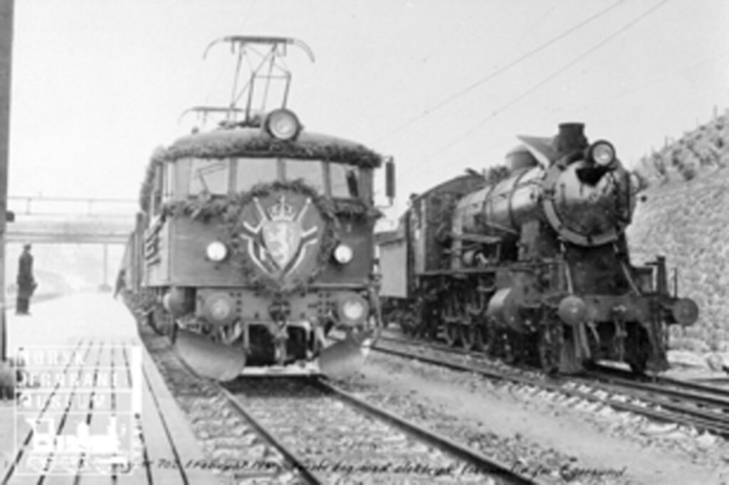 Egersund stasjon med åpningstog for elektrisk drift på Sørlandsbanen i 1950, tog 702 trukket av elektrisk lokomotiv type El 8 nr. 2065 ved siden av …